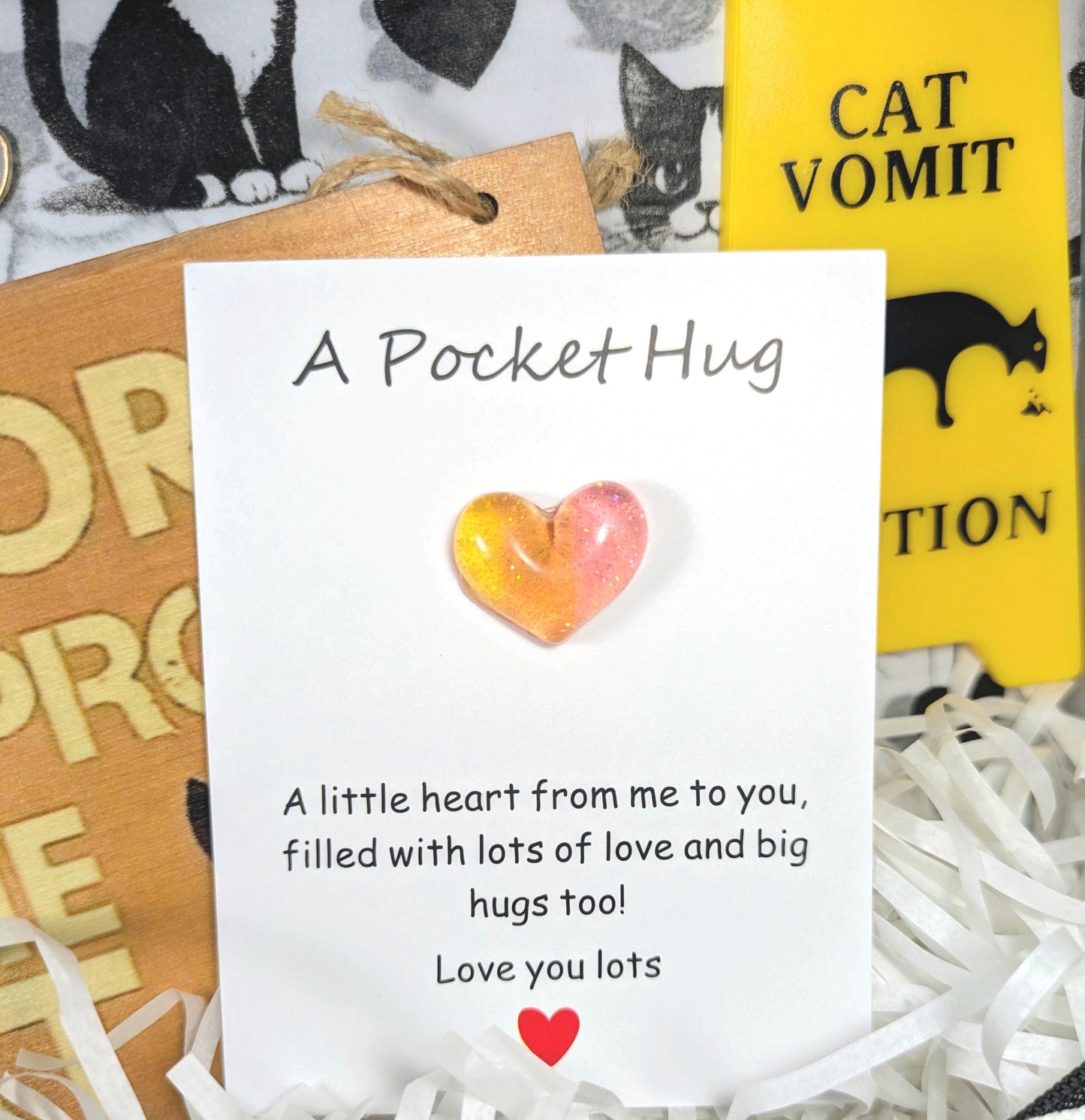 Personalised gift card with glass heart and printed message, accompanied by cat-themed wooden and yellow signs.