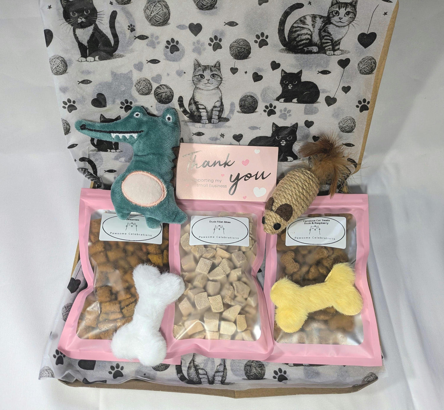Personalised cat treat box with crochet toys and three bags of assorted cat treats in a cat-themed gift box.