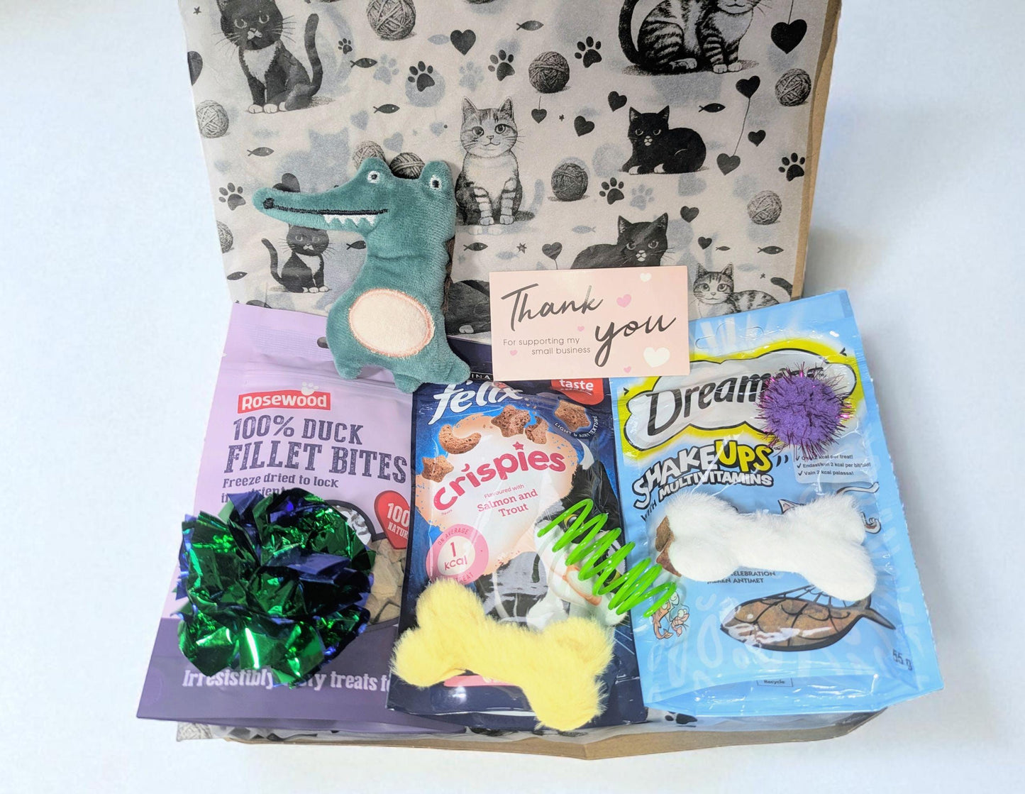 Large cat treat box with duck fillet bites, fish-shaped toys, spring toys, and thank you card in decorative packaging.