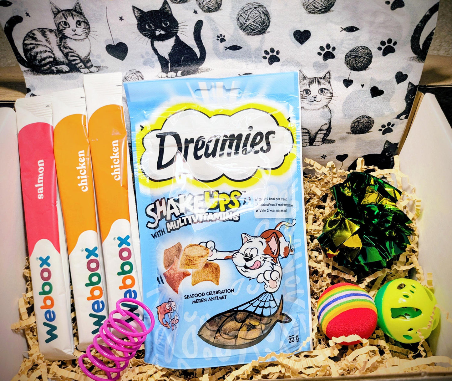 Personalised cat treat box with Dreamies cat snacks, colorful toys, and a cat-themed gift bag.