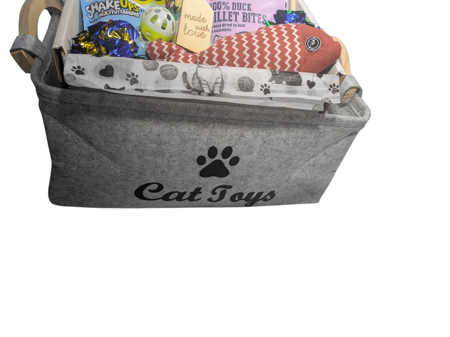 Grey felt cat toy basket with paw print design, containing fish-shaped toy, treats, and snack packages.