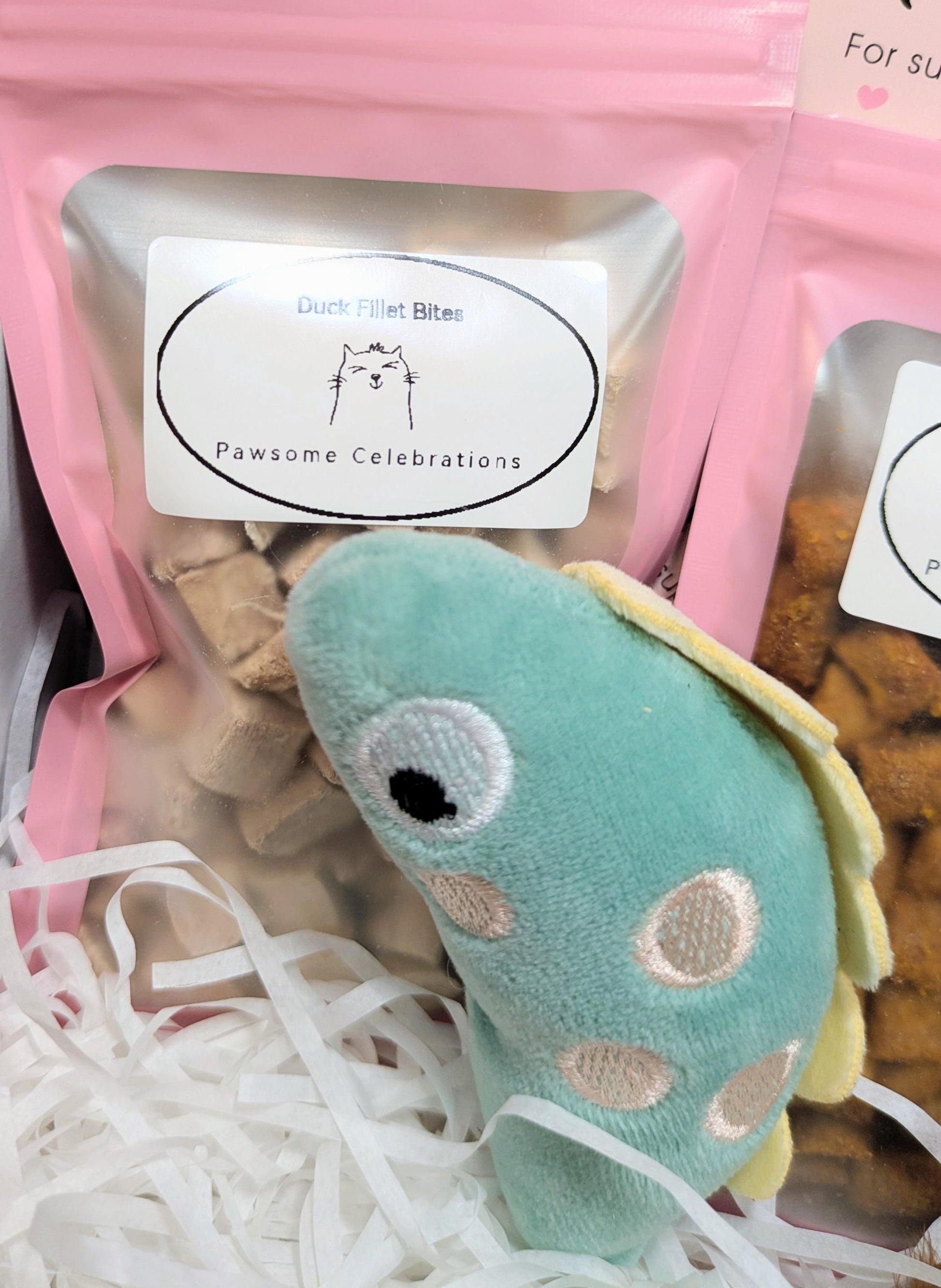 Medium cat treat box with pink packaging, handmade toys, and shredded paper filler.