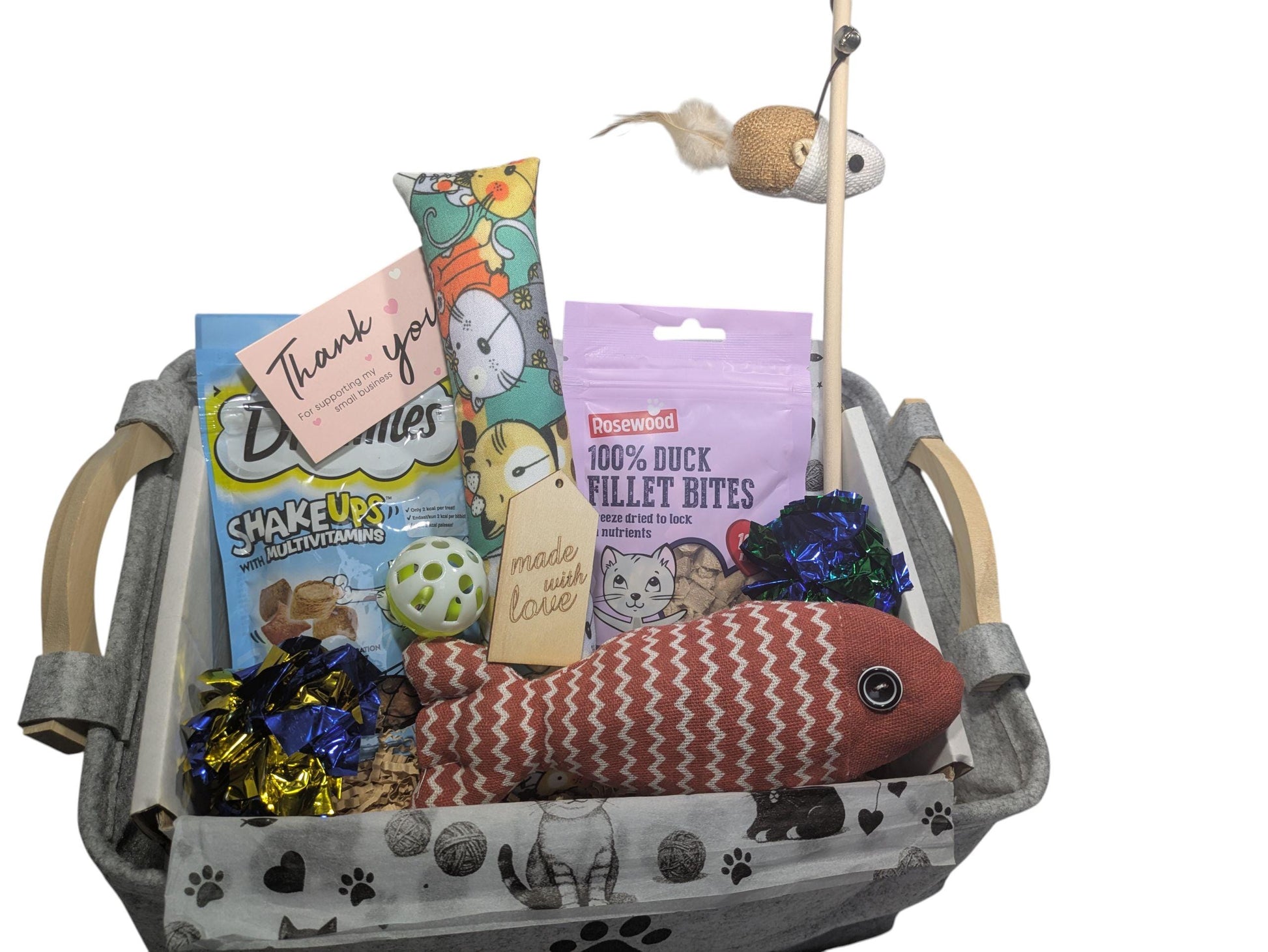 Gray woven basket filled with cat toys, treats, a wand with a mouse, and a thank you card.