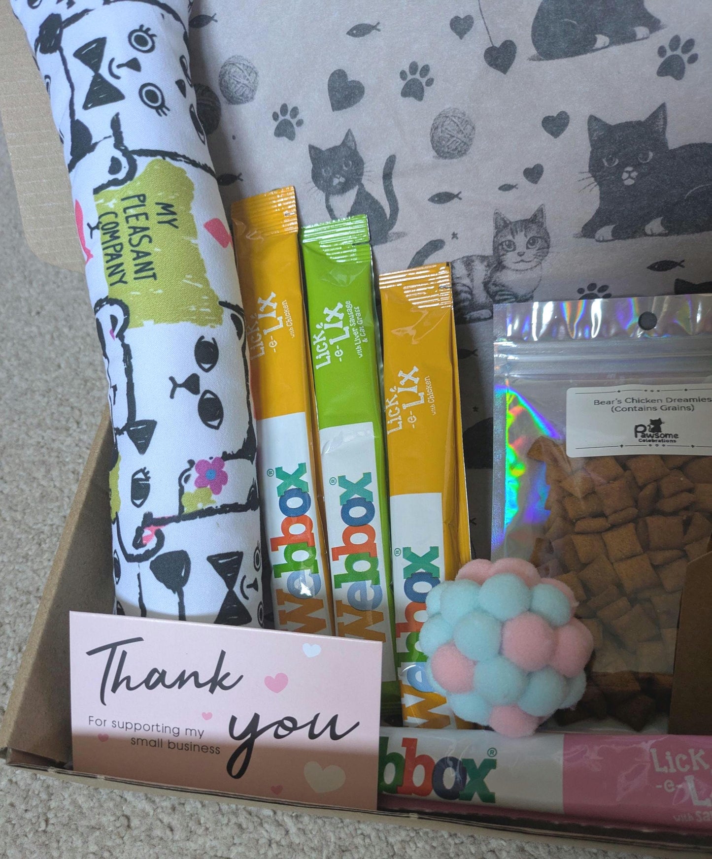 Small cat treat box with catnip kicker toy, three colorful treat sticks, and thank you card in gift box with cat pattern.