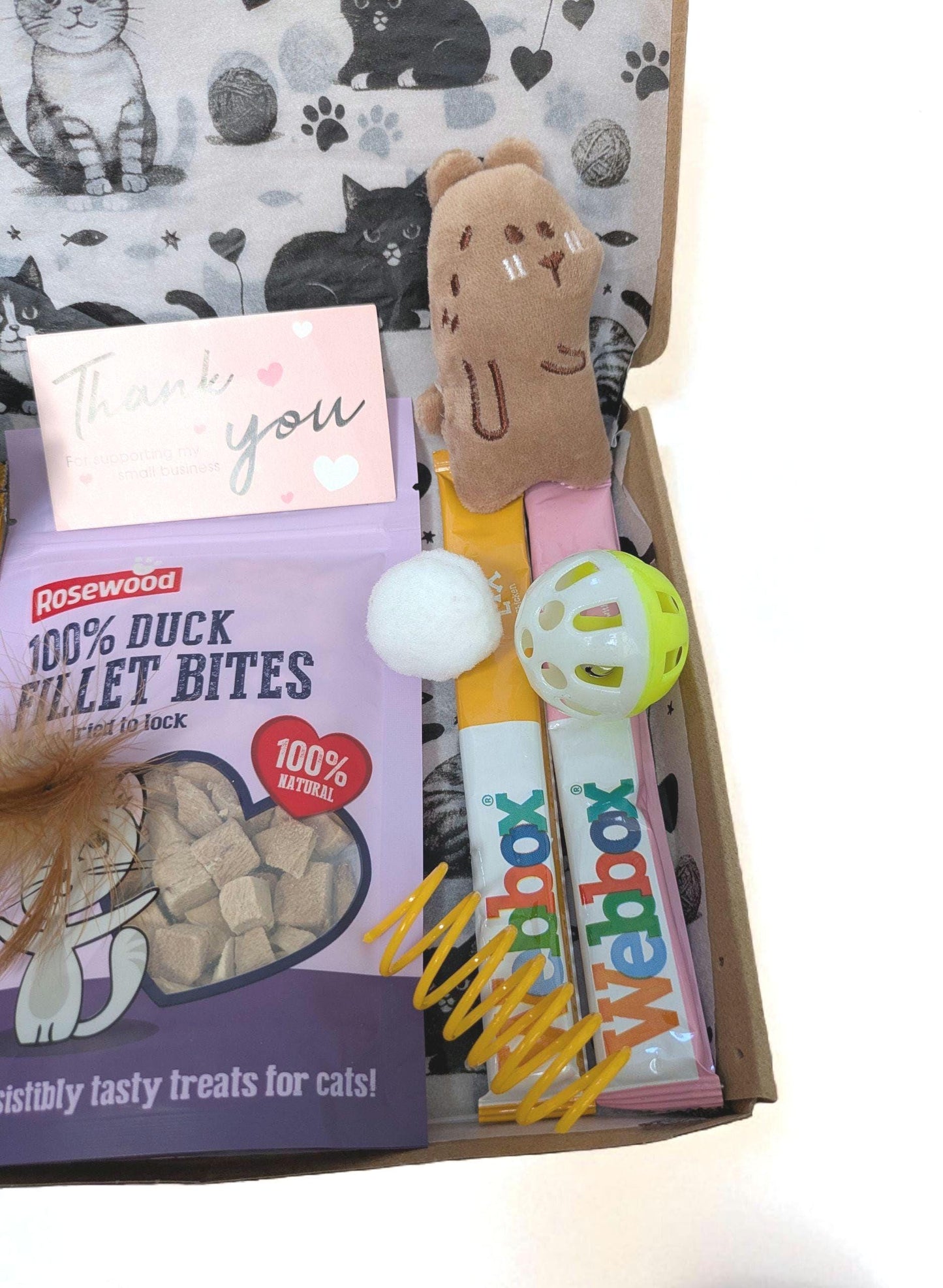 Open personalised cat treat box with duck pellet bites, plush mouse toy, feather ball, and spring toy.