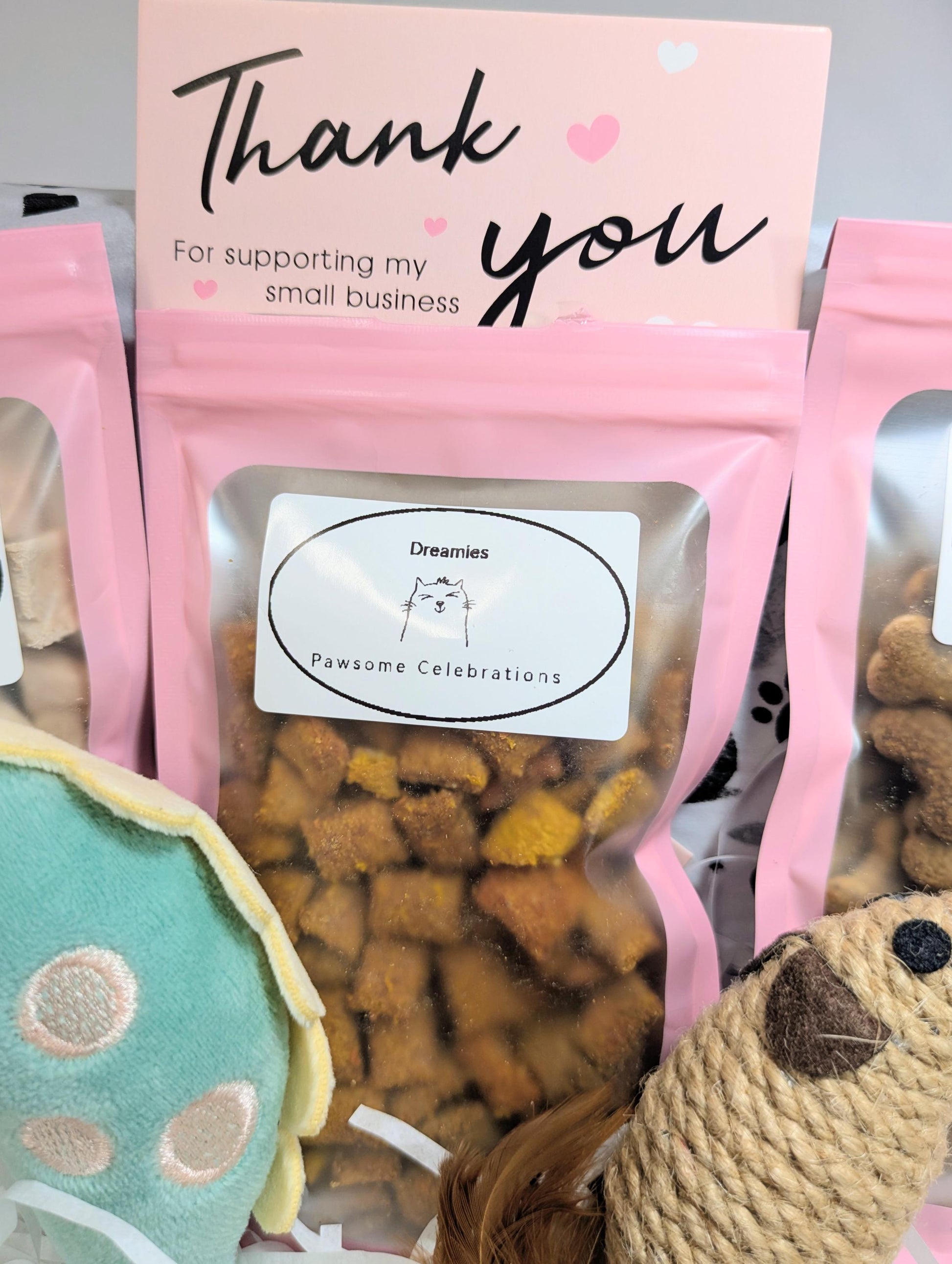 Pink resealable bag of handmade cat treats with a thank you card and a green cat toy partially visible.