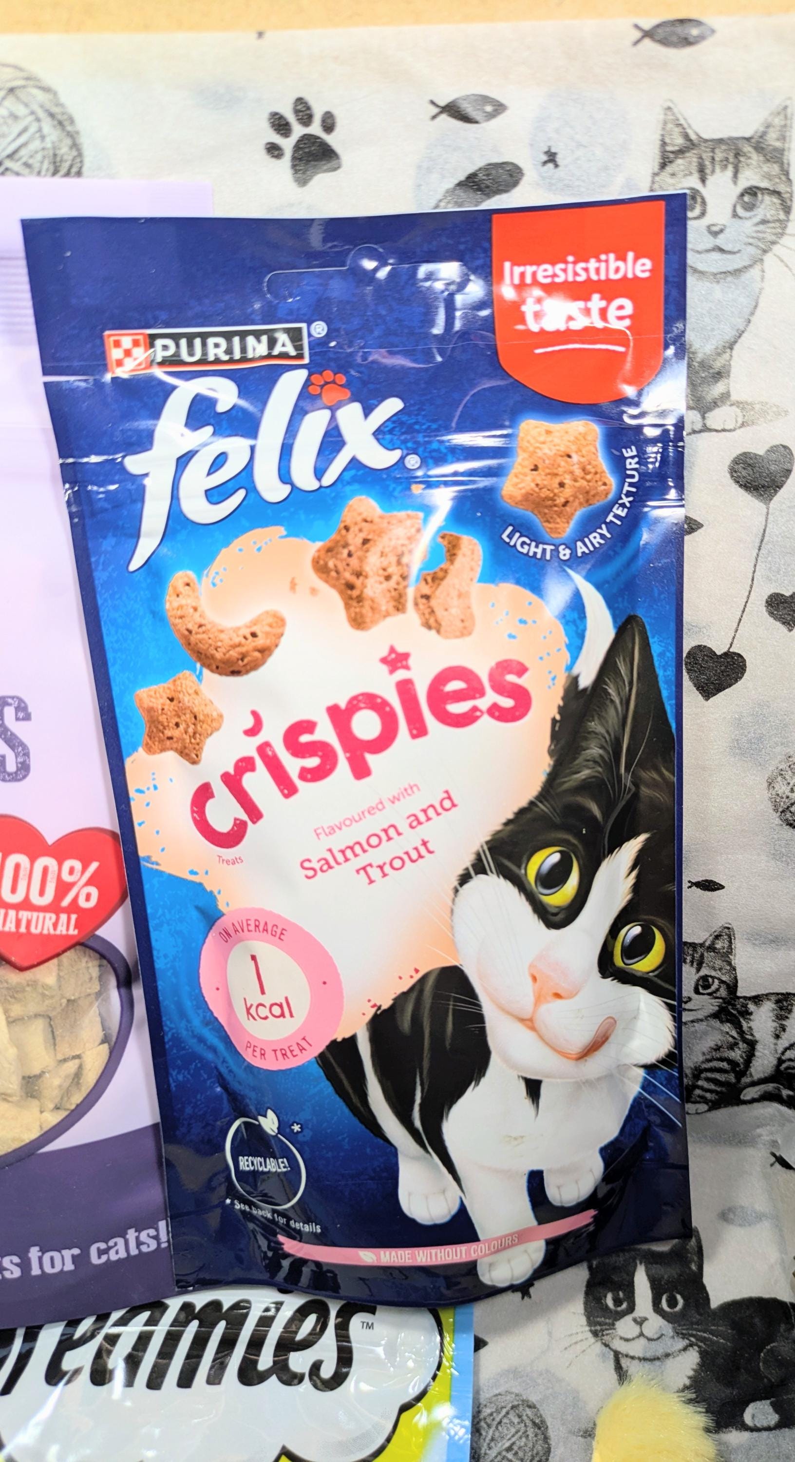 Blue bag of Purina Felix Crispies cat treats with a black and white cat illustration on the front.